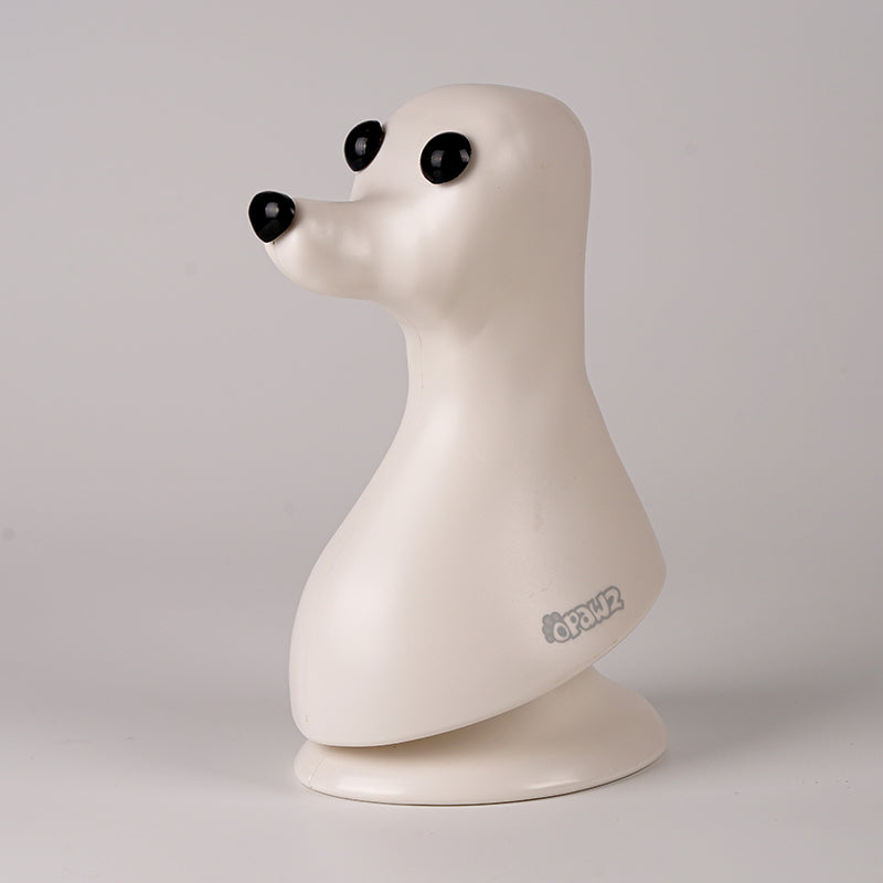 A plastic model of a dog head, designed in a teddybear style with black eyes, on a plain background.