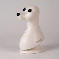 A plastic model of a dog head, designed in a teddybear style with black eyes, on a plain background.