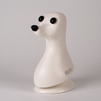 A plastic model of a dog head, designed in a teddybear style with black eyes, on a plain background.