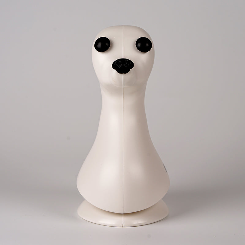 A plastic model of a dog head, designed in a teddybear style with black eyes, on a plain background.