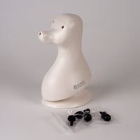 A plastic model of a dog head, designed in a teddybear style with black eyes, on a plain background.