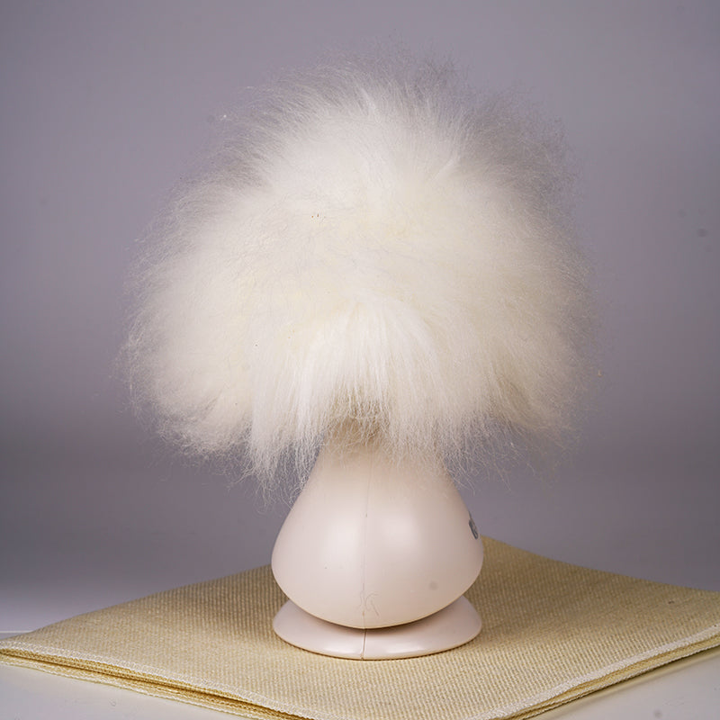 A white synthetic fiber dog wig displayed on a mannequin head, resembling a fluffy dog with black eyes and a pink collar.