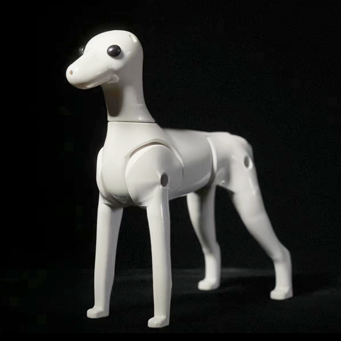 A white, moveable-joint plastic model of a Schnauzer dog.