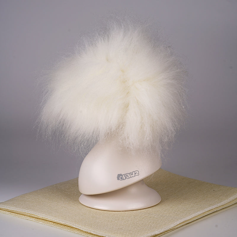 A white synthetic fiber dog wig displayed on a mannequin head, resembling a fluffy dog with black eyes and a pink collar.